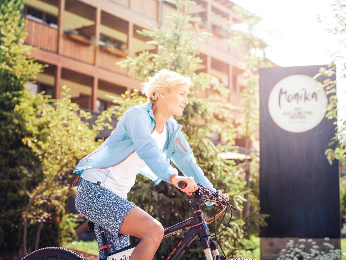 Hotel Monika Sexten Esterno foto A woman cycling in the resort